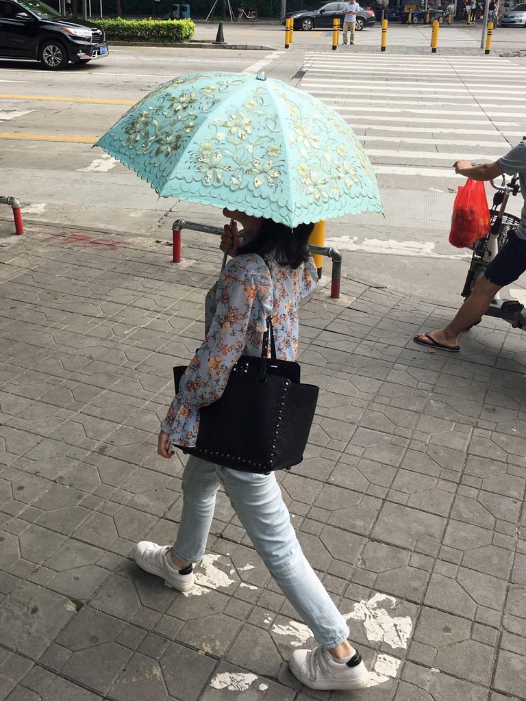 It may be 90F/31C but the women in China will wear long pants and long-sleeve shirts, and carry a parasol to keep their skin pale