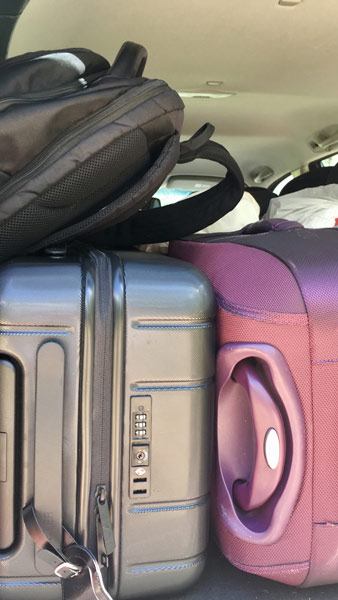 Shows picture of suitcases in the back of the car