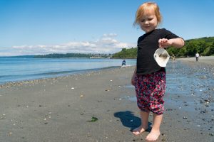 toddler holding a seashell at Discovery Park